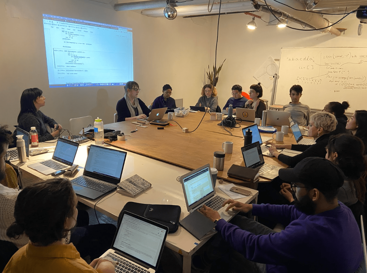 Allison Parrish and Code Societies students sit around a table during the Computational Exploration of Magical and Divinatory languages class.