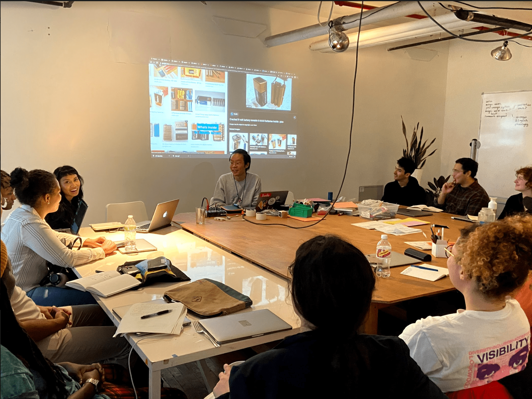 Taeyoon Choi in Code Societies classroom with group of students. Pictures of batteries display on the projector