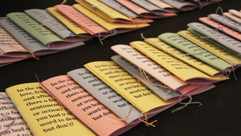multicolor handmade booklets, or zines, laid out on a table
